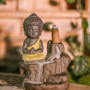 A peaceful Buddha figurine with an incense burner, emitting calming smoke in a zen environment.